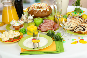 Fototapeta na wymiar Serving Easter table with tasty dishes on room background