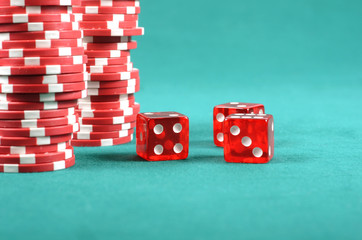 Red poker gambling chips on a green playing table
