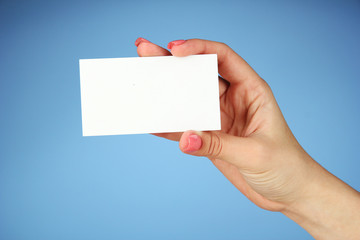 Obraz premium Female hand holding business card, on color background