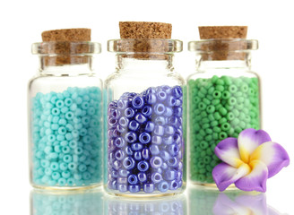 Little bottles full with colorful beads isolated on white
