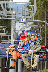 Naklejka premium Lovely couple sitting on chairlift