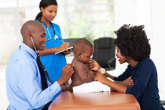male doctor examining a baby boy