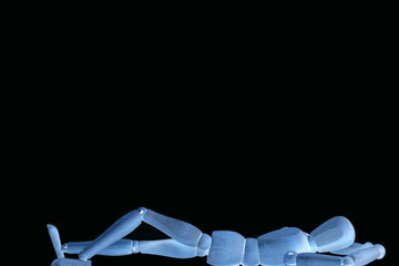 Liegende Holzpuppe auf schwarzem Hintergrund