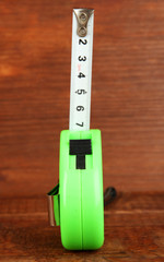 Tape measure on wooden background