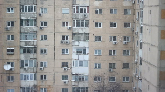 Snow falling over buildings constructed during the communist era