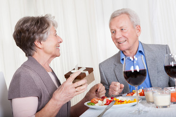 Senior Man Giving Gift To Senior Woman