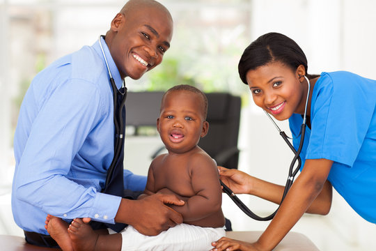 female nurse examining little boy with male doctor
