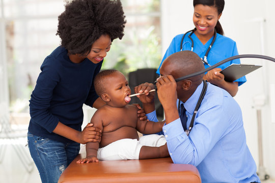 male african doctor examining little boy