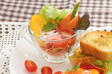 fresh vegetable and crab stick salad in glass bowl 