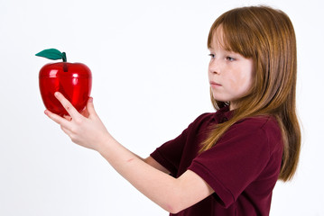 Female school child holding a clear plastic apple