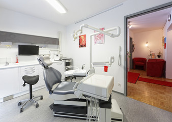 Moderner Zahnarztstuhl mit Wartezimmer im Hintergrund