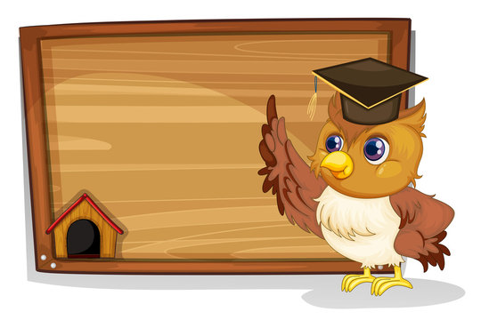 An owl wearing a graduation cap beside a wooden board