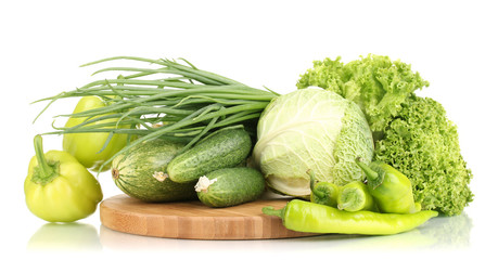 fresh green vegetables on chopping board isolated on white