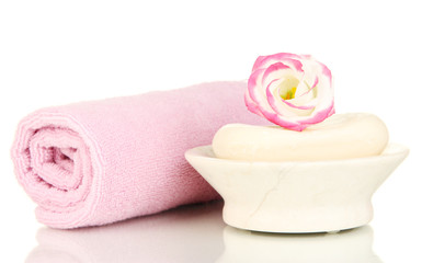 Fototapeta na wymiar Rolled różowy ręcznik, mydła i piękny kwiat samodzielnie