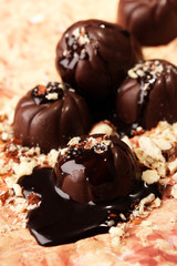 Chocolate candies with nuts, on color background
