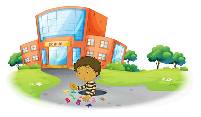 A boy playing in front of the school building