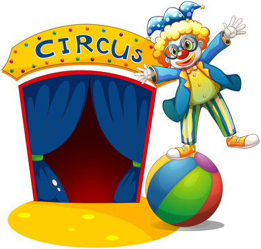 A clown at the top of the ball beside a circus house