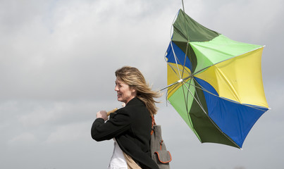 Woman struggles with  inside-out umbrella