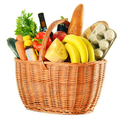 Wicker basket with variety of grocery products isolated on white