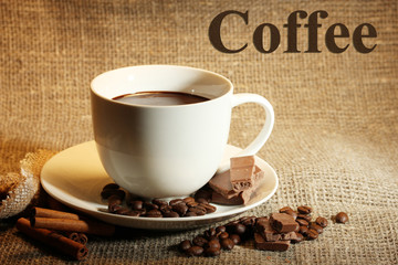 Cup of coffee and beans, cinnamon sticks and chocolate
