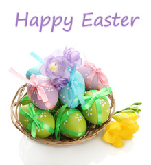 Bright easter eggs with bows in basket, isolated on white