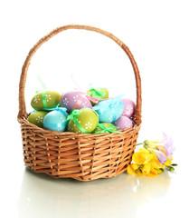 Bright easter eggs with bows in basket, isolated on white