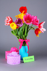 Beautiful tulips in bouquet with gifts and note