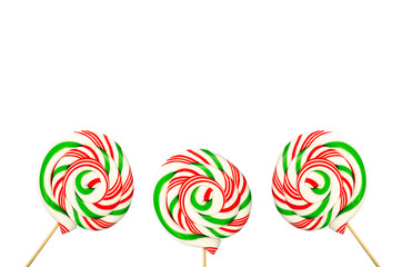 Fototapeta na wymiar Three sugar lollipops in white green and red isolated on white b