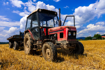 red old tractor in summer on field