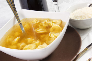 broth with ravioli over  white tablecloth