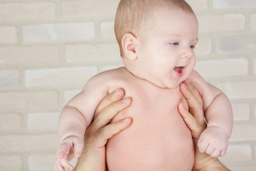 Smiling baby in the arms of his father.