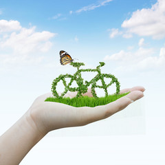 hand holding bicycle made out of green leaves