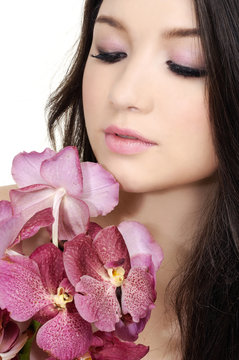 Portrait of beautiful woman face holding brunch orchid