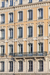 Fototapeta na wymiar façade jaune d'immeuble ancien avec fenêtres à Lyon