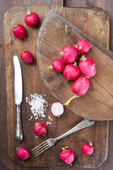 Still life with radishes and salt on a wooden background