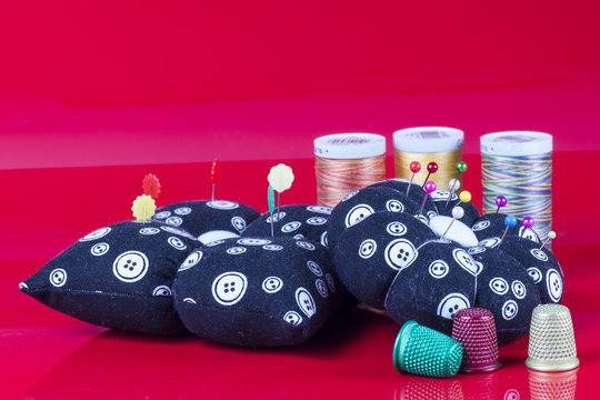 Neddle Case, Spools and Thimbles Isolated on Red.