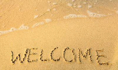 Welcome - written in sand on beach texture