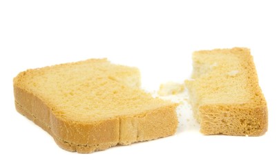 A broken slice of crispbread and crumbs on a white background