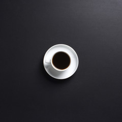 A white cup of tasty coffee on a dark grey background