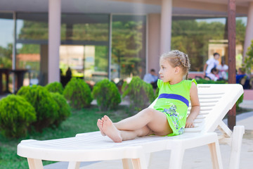Beautiful little girl resting on a lounge  © len44ik