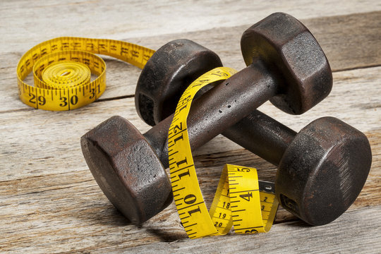iron dumbbells and measuring tape