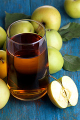 Useful apple juice with apples around on wooden table
