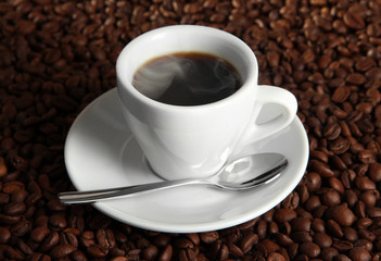 Cup of coffee on coffee beans background