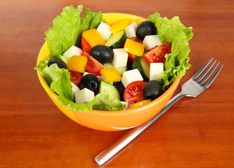 Tasty Greek salad on wooden background