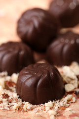 Chocolate candies with nuts, on color background