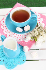 Beautiful tea composition on wooden picnic table close-up