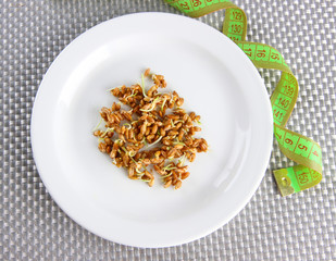 Wheat germs on plate and measuring tape, close up