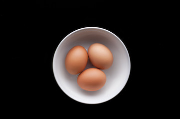Tres huevos en bol con fondo negro
