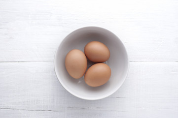 Tres huevos en bol con fondo blanco