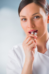 Young female dentist doctor holding chewing gum and smiling. Den